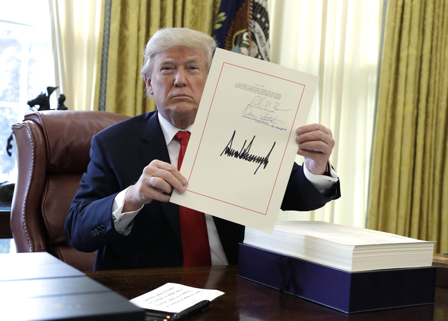 President Donald Trump signs tax bill into law, saying it's 'selling itself'
